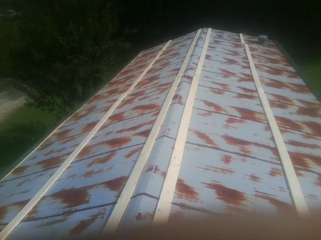 Rusted metal roof panels with new wood purlins before replacement — Storm Damage Roof Repair in Angier by Roofing Brothers