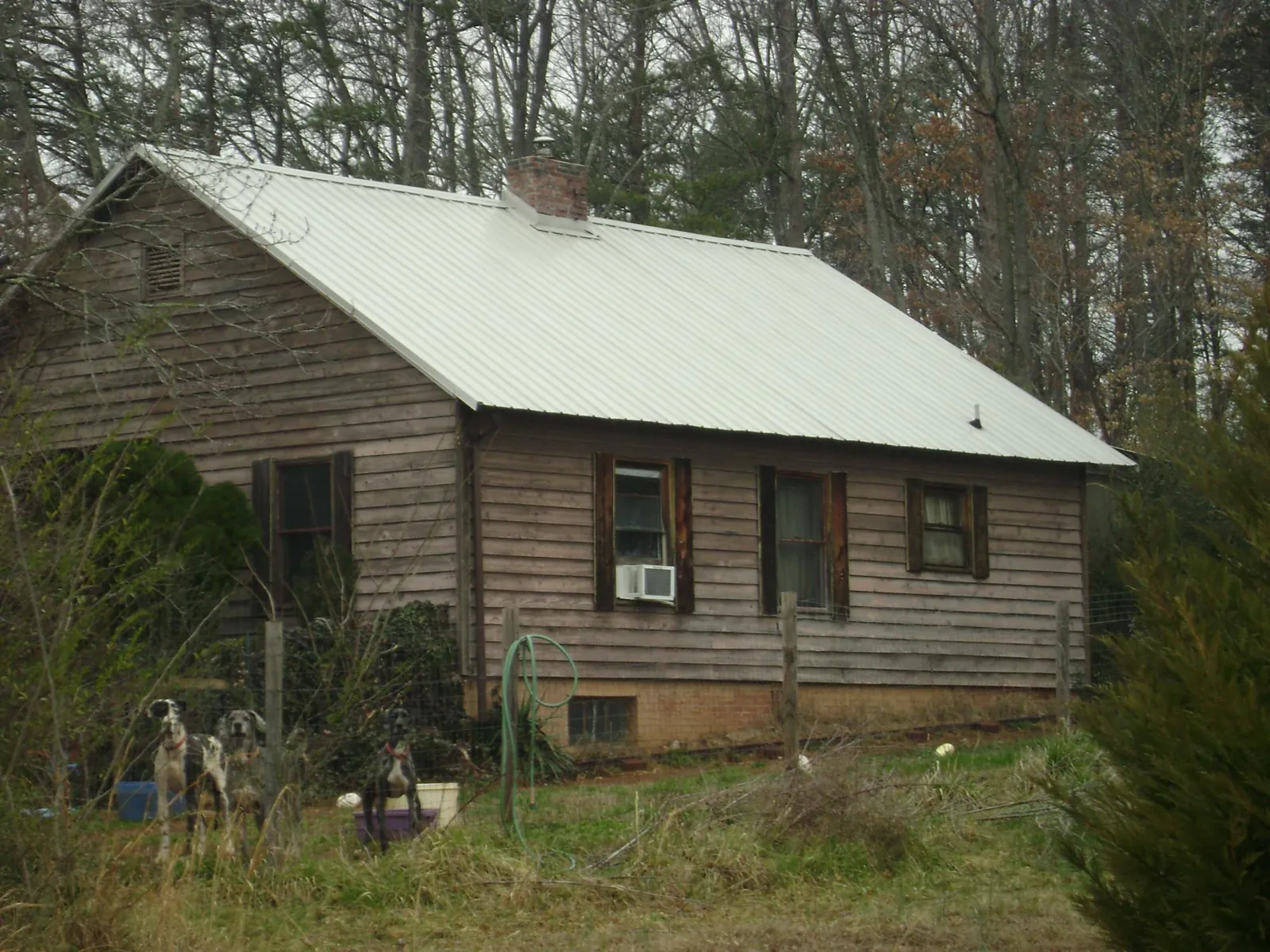 White metal roof on an old wood sided farmhouse, from a Metal Roof Installation job in Angier